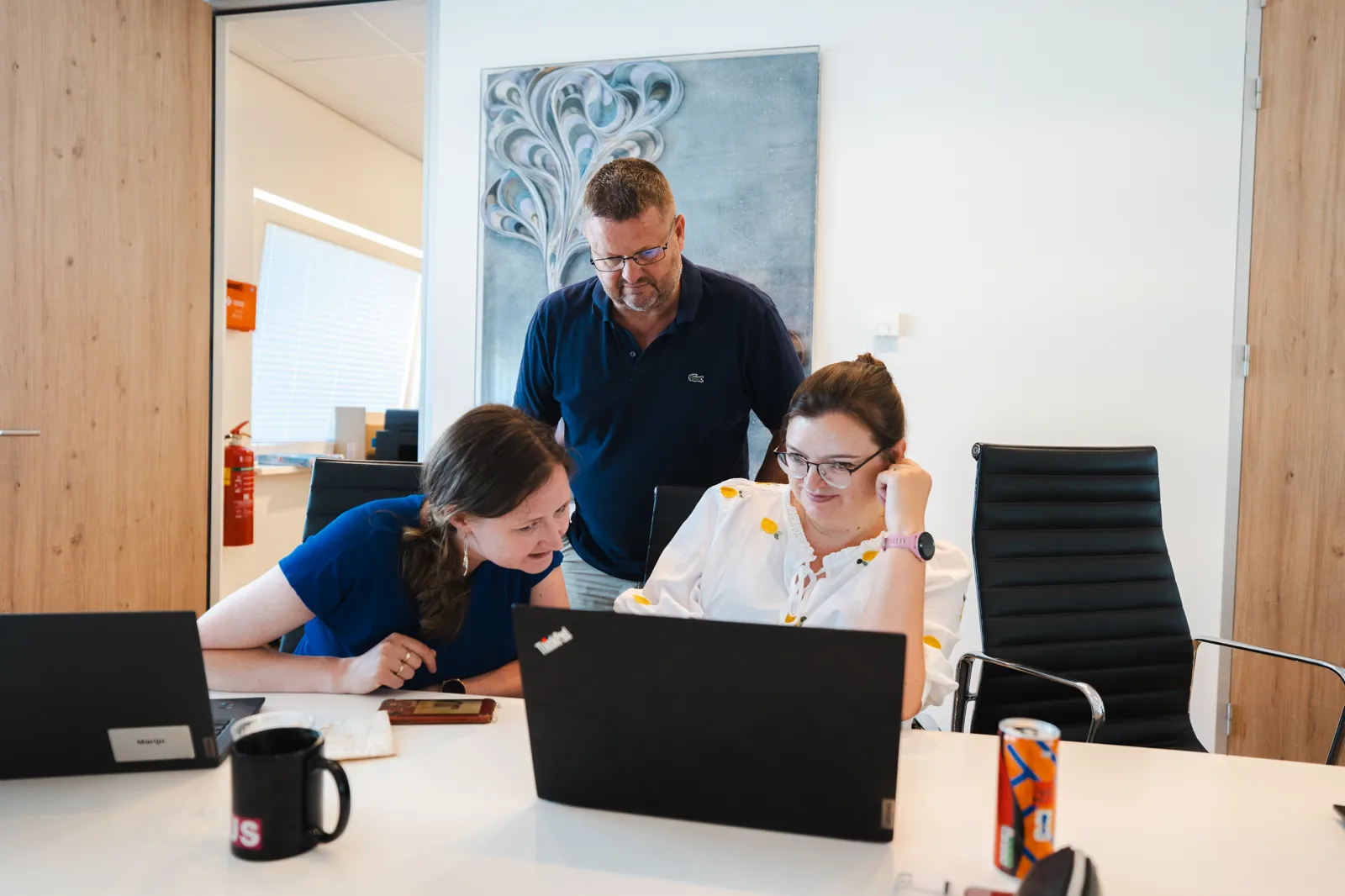Workshopbegeleider kijkt met een deelnemer mee op diens eigen werk op een laptop