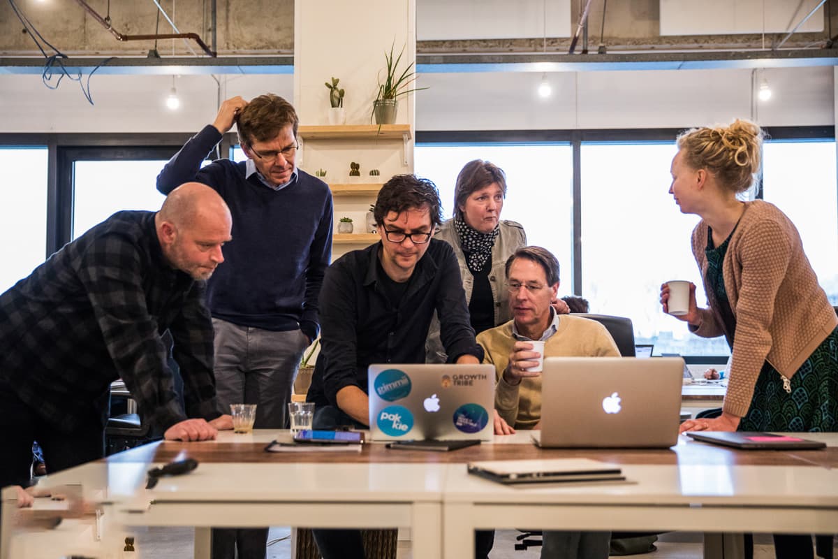 Workshop deelnemers werken samen rond laptops